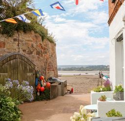An outdoor area with a stone wall and fishing gear at Tower View Cottage in Lympstone