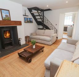 A living room with a fireplace and staircase at The Lookout in Redruth