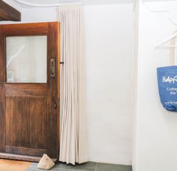 An entrance with a wooden door and a bag at The Hayloft at Manaton