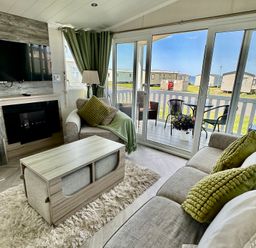 A living room with a television and a coffee table at Craig Tara Holiday Park 101 Bay View Ayr