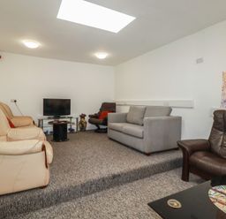 A living room with a television and seating at Newseal House