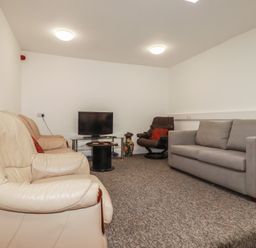 A living room with a sofa and television at Newseal House