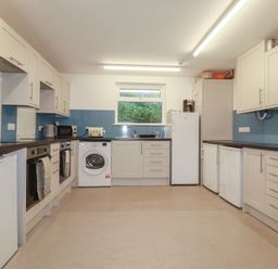 A kitchen with cabinets and appliances at Newseal House