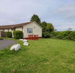 A house with a table and chairs in the garden at Cottage 28 in Brixham