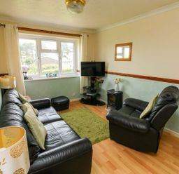 A living room with a sofa and television at Cottage 28 in Brixham
