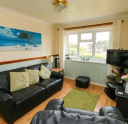A living room with a sofa and television at Cottage 28 in Brixham