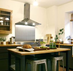 A kitchen with a wooden table and stainless steel hood at Beautiful 6Bed Sleeps 12 Stunning Views in Lynton
