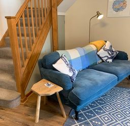 A living room with a sofa and staircase at 1 bed cottage Parking Patio close to coasts Coads Green near Launceston
