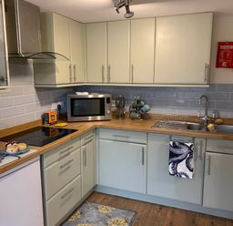 A kitchen with cabinets, stove, sink, microwave at 1 bed cottage Parking Patio close to coasts Coads Green near Launceston