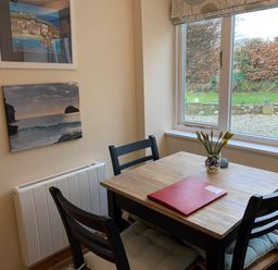 A dining room with a table and chairs at 1 bed cottage Parking Patio close to coasts Coads Green near Launceston