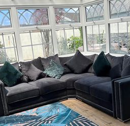 A conservatory with a sofa and windows at Build your memories hot tub garden sleeps 14 in Nottage