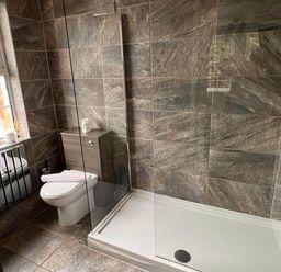 A bathroom with a toilet, sink, and shower at Build your memories hot tub garden sleeps 14 in Nottage