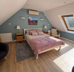 A bedroom with a bed and windows at River Tamar Couples Retreat Dog Friendly in Newbridge