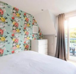 A bedroom with floral wallpaper and a dresser at 2 Bedrooms overlooking Little Petherick Creek in Little Petherick
