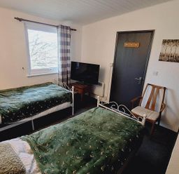 A bedroom with two beds and a television at Forest Retreat Sleeps 4 2Bed with Parking Woolsery near Bideford