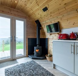 A living room with double doors and a wood stove at The Lodge at Brambles Farm Sleeps 4 Hot Tub in Leek