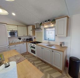 A kitchen with cabinets and appliances at Lakeland Lodge 3Bed 2 Bath Private Patio in Carnforth