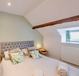 A bedroom with a bed and bedside tables at Cottage Sleeps 5 with Parking and Garden in Carreglefn