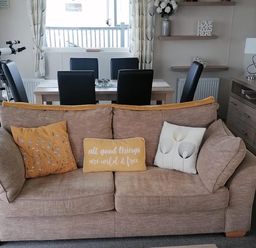 A living room with a sofa and dining area at Seaside Lodge Retreat in Eyemouth