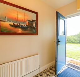An entryway with a painting and front door at Biddy Granny's