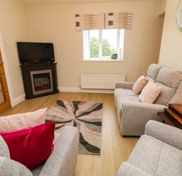 A living room with a sofa and television at Biddy Granny's