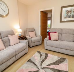 A living room with sofas and a lamp at Biddy Granny's 
