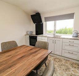 A kitchen with a dining table and chairs at Biddy Granny's