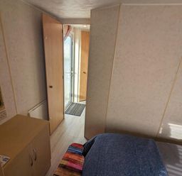 A bedroom with a bed and a door leading outside at Sandy Paws Dog Friendly Anderby Creek