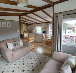 A living room with a sofa and dining area at The Old Barn in Builth Wells