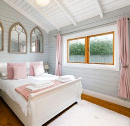 A bedroom with a bed and mirrors at