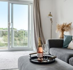 A living room with a champagne bottle and glasses on a tray at Spacious 3 Bed House Sleeps 6 Parking Wifi Newquay