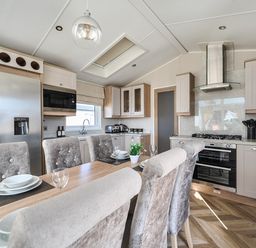 A kitchen with appliances and dining area at 2Br Lodge Pool Fireplace PetsOK Parking Goonhavern