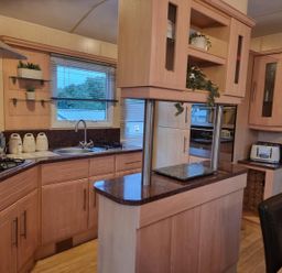A kitchen with cabinets and appliances at Chalet Sleeps 6 swimming pool Thorness Bay