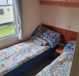 A bedroom with twin beds and a window at Chalet Sleeps 6 swimming pool Thorness Bay