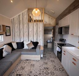 A living room with a sofa and kitchen unit at Selfcatering Lodge Inverness Sleeps 4 Inverness