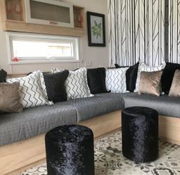 A living room with a sofa and pillows at Selfcatering Lodge Inverness Sleeps 4 in Inverness