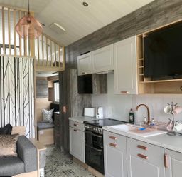 A kitchen with appliances and seating area at Selfcatering Lodge Inverness Sleeps 4 in Inverness