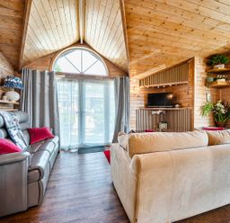 A living room with a sofa and television at Alpaca Farm Valley Views Sleeps 4 Parking Pets in Husthwaite