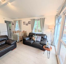 A living room with kitchen area and dining table at Felmoor Park Northumberland Lodge with Hot Tub near Felton