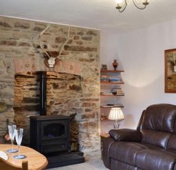 A living room with a stove and dining table at The Old Barn in Manchester