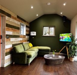 A living room with a green sofa and a television at a property