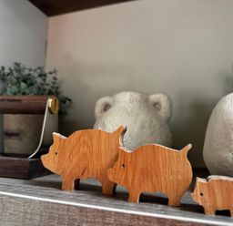 Three wooden pig figures and ceramic vases in a kitchen