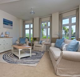 A living room with a sofa and armchair at 4 The Salcombe in Salcombe