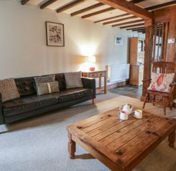 A living room with a sofa and coffee table at Dewi Villa Apartment in Aberaeron