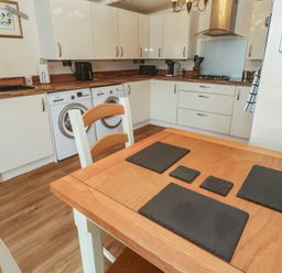A kitchen with table and appliances at The Hideaway at Monterey Helston