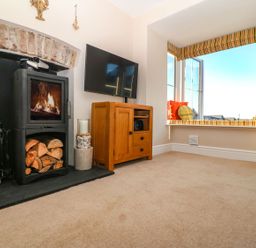 A living room with a fireplace and television at Bryn Tirion - Rhosneigr