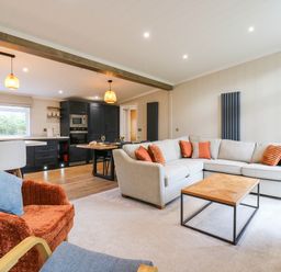 A living room with a sofa and coffee table at Cherry Lodge in Battisford near Stowmarket