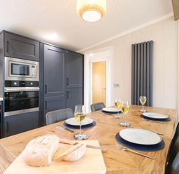 A kitchen with a dining table set for a meal at Cherry Lodge in Battisford near Stowmarket