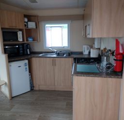 A kitchen with cabinets and appliances at Golden Sands FSB38 in Rhyl