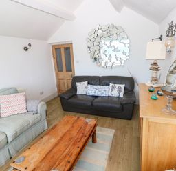 A living room with a sofa and coffee table at Y Glyn in Borth